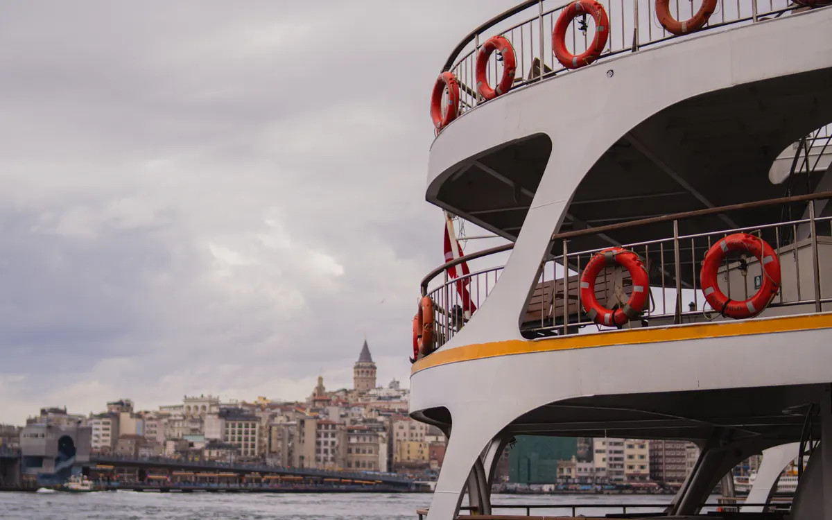 A passenger ferry crossing the Bosphorus near Galata Tower