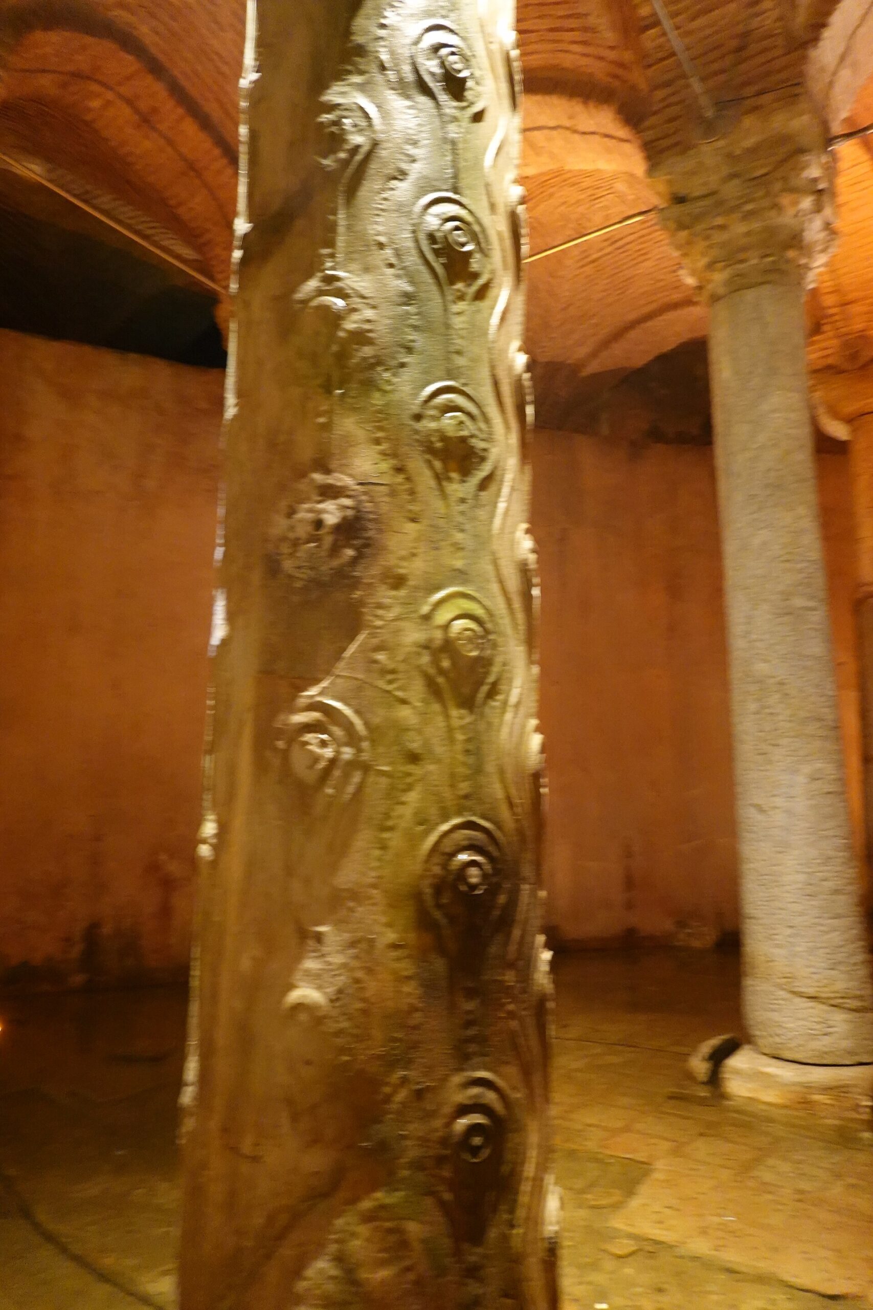 Carved stone column lit by warm light in the Basilica Cistern