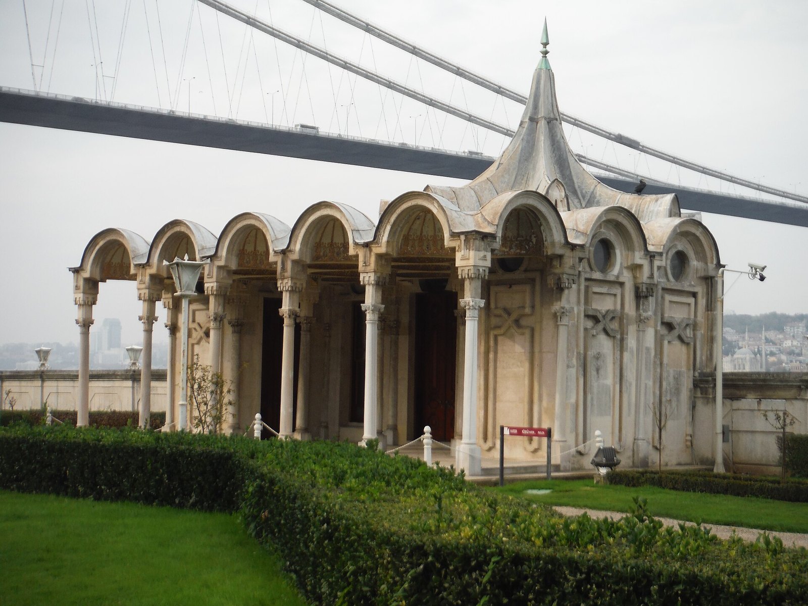 Marble sea pavilion with arched colonnade beneath the Bosphorus Bridge cables
