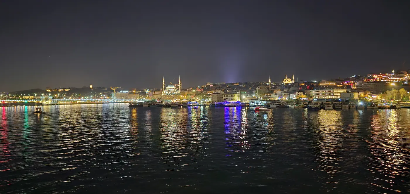 Golden Horn Istanbul at night with illuminated mosques and ferries