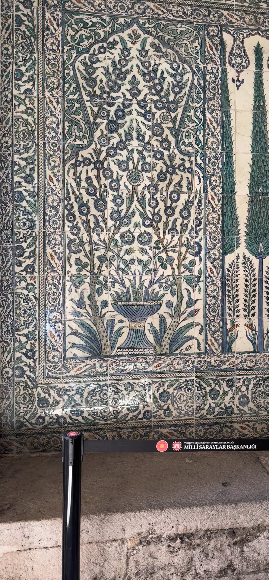 Iznik tile panel with a vase of flowers and rows of tall green cypress trees in the Topkapı Harem