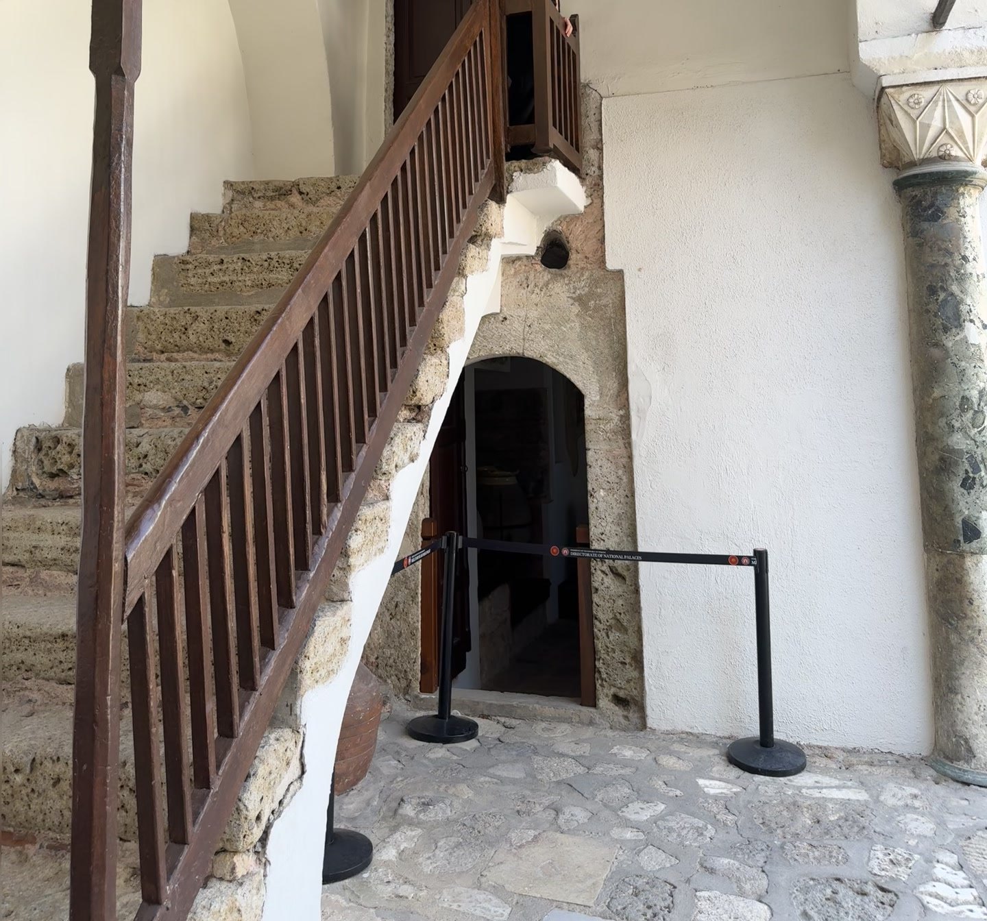 Wooden staircase with stone steps and a low arched doorway beneath it in the Topkapı Harem