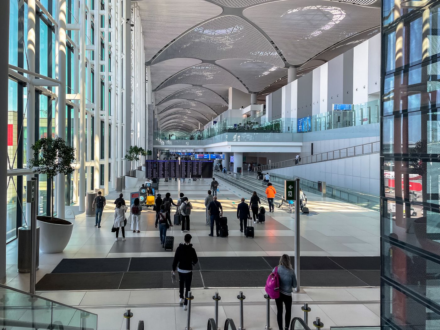 Travellers carrying suitcases through Istanbul Airport terminal