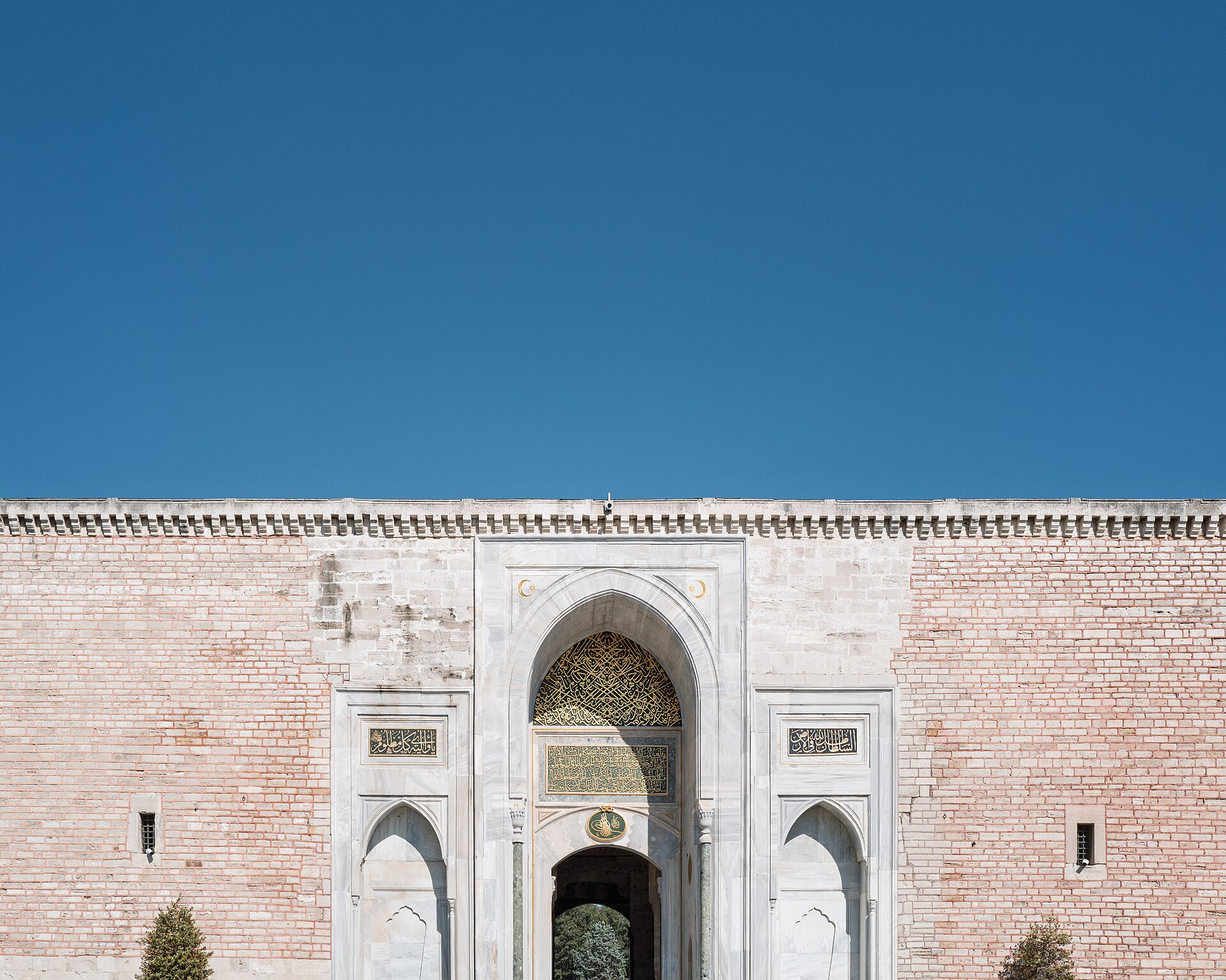 Pointed archway of the Imperial Gate at Topkapı Palace under a clear sky