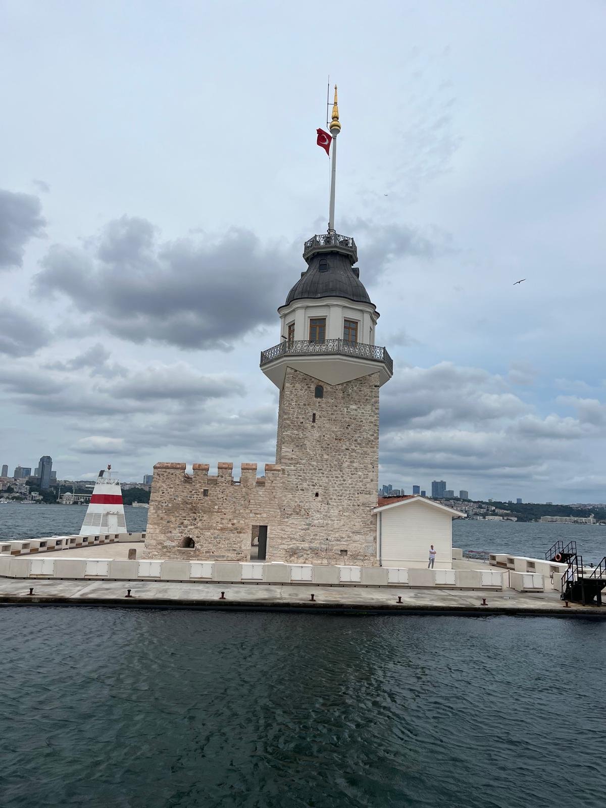 The tower, its stone bastion and a small red-and-white beacon at the edge of the islet