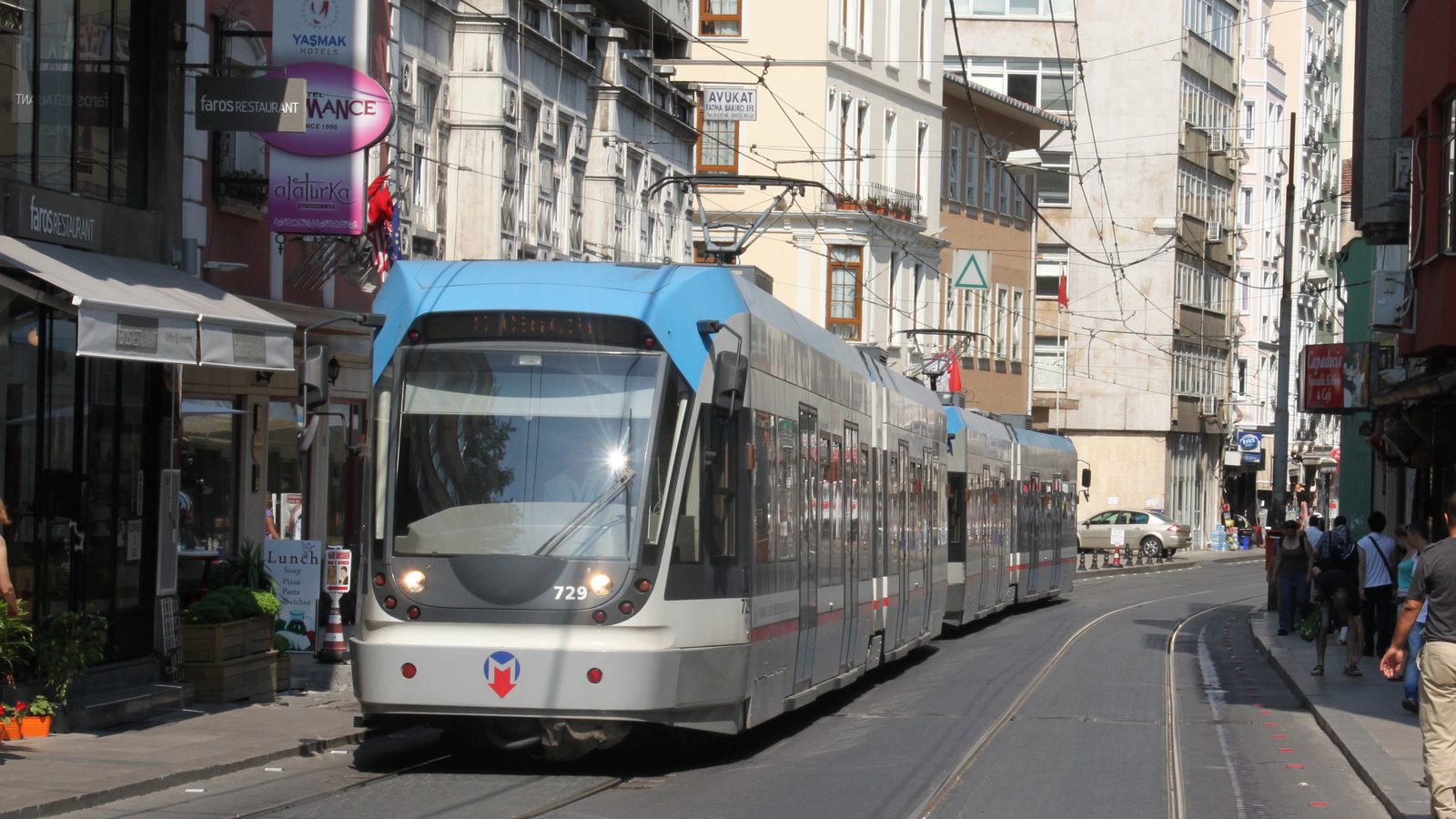 A T1 tram running along a narrow shopping street in Sirkeci, Istanbul